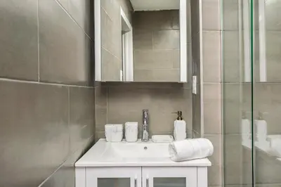 a bathroom with a white sink and a mirror at 109-1 Huge 3BR Best Value Amazing NYC Apt in New York