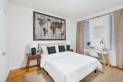 a white bedroom with a large bed and a desk at 109-1 Huge 3BR Best Value Amazing NYC Apt in New York
