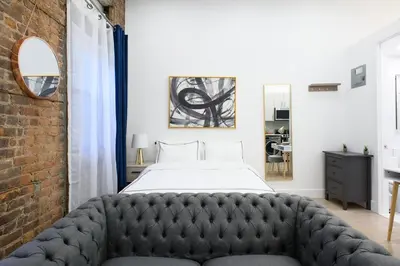 a bedroom with a bed and a brick wall at 62-2B NEW Prime UES W D in unit in New York