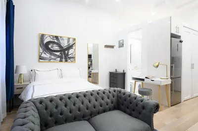 a bedroom with a large bed and a couch at 62-2B NEW Prime UES W D in unit in New York