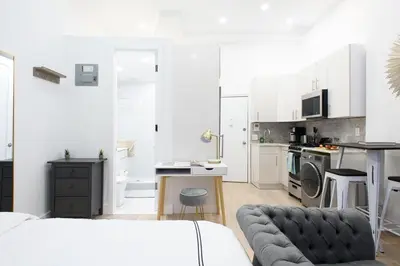 a living room with a couch and a kitchen at 62-2B NEW Prime UES W D in unit in New York