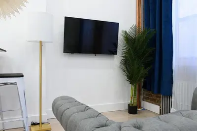 a living room with a couch and a flat screen tv at 62-2B NEW Prime UES W D in unit in New York