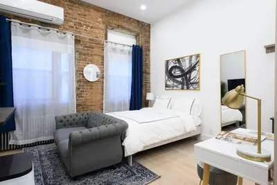 a bedroom with a bed and a couch and a chair at 62-2B NEW Prime UES W D in unit in New York