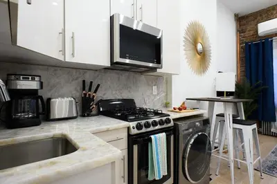 a kitchen with a stove top oven next to a sink at 62-2B NEW Prime UES W D in unit in New York