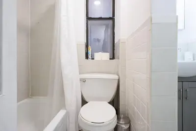 a white bathroom with a toilet and a sink at 428-3R Spacious Prime Midtown 2BR Newly furnished in New York