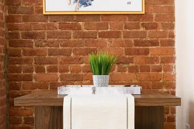 a brick wall with a table with a plant on it at 428-4R prime midtown large 2 BR Newly Furnished in New York