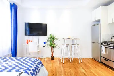 a bedroom with a bed and a kitchen with a table at 62-3B Studio Prime UES Walk to Central Park in New York