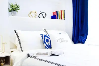 a bedroom with a white bed with a book on it at 62-3B Studio Prime UES Walk to Central Park in New York