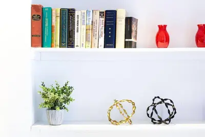a shelf with books and vases and a plant at 62-3B Studio Prime UES Walk to Central Park in New York