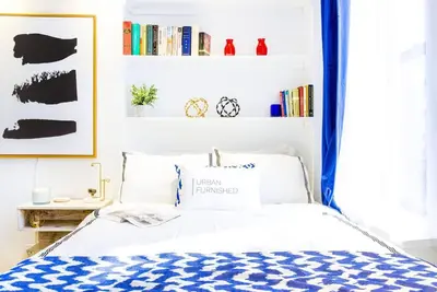 a bedroom with a bed with a blue curtain at 62-3B Studio Prime UES Walk to Central Park in New York