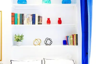 a shelf with books and vases on it at 62-3B Studio Prime UES Walk to Central Park in New York