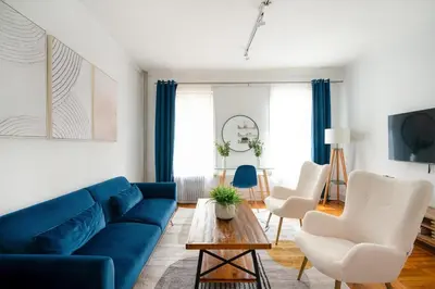 a living room with a blue couch and white chairs at 61-2A Large 1BR in Upper East Side in New York