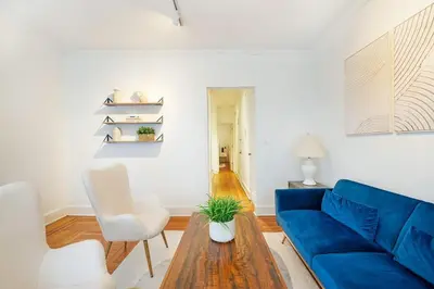 a living room with a blue couch and a table at 61-2A Large 1BR in Upper East Side in New York