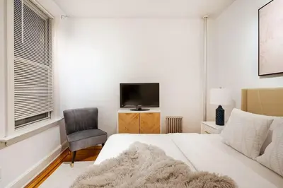 a bedroom with a bed and a tv and a chair at 61-2A Large 1BR in Upper East Side in New York