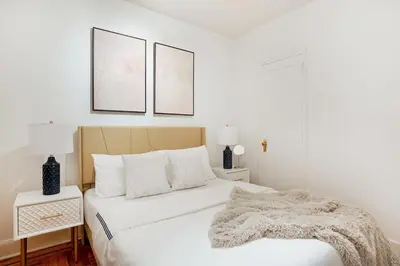 a white bedroom with a bed with a blanket on it at 61-2A Large 1BR in Upper East Side in New York