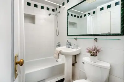 a bathroom with a sink and a toilet and a mirror at 61-2A Large 1BR in Upper East Side in New York