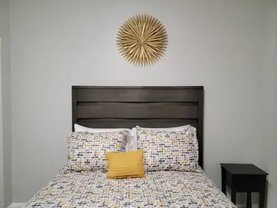 a bed with a wooden headboard and a yellow pillow at Room for rent in Apartment in Hartford
