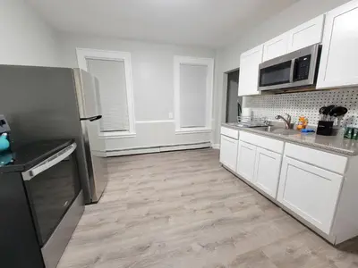 a kitchen with white cabinets and a stainless steel refrigerator at Room for rent in Apartment in Hartford
