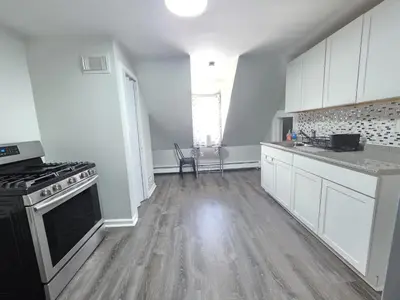 a kitchen with white cabinets and a black stove at Room for rent in Apartment in Hartford