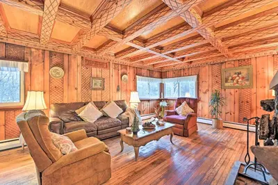 a living room with a couch and a table at Old Time Catskill Mtn Retreat, Handcrafted Cabin! in Cornwallville