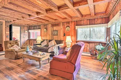 a living room with a couch and a table at Old Time Catskill Mtn Retreat, Handcrafted Cabin! in Cornwallville