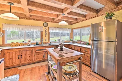 a kitchen with wooden cabinets and a stainless steel refrigerator at Old Time Catskill Mtn Retreat, Handcrafted Cabin! in Cornwallville