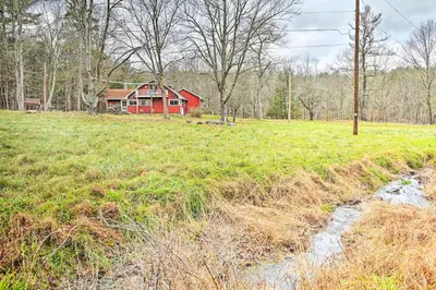 a red house in the middle of a field at Old Time Catskill Mtn Retreat, Handcrafted Cabin! in Cornwallville