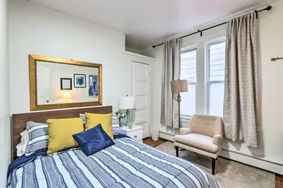 a bedroom with a bed and a chair and a mirror at Hartford Vacation Rental - Close to Downtown! in Hartford