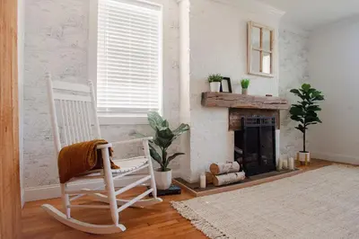a room with a rocking chair and a fireplace at Farmhouse Broad Brook: Comfort & Charm. in East Windsor