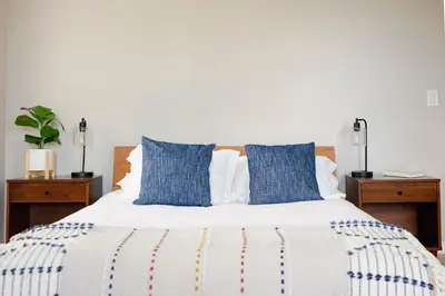 a bedroom with a bed with blue pillows at Farmhouse Broad Brook: Comfort & Charm. in East Windsor