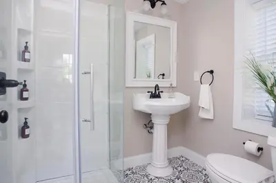 a white bathroom with a sink and a shower at Farmhouse Broad Brook: Comfort & Charm. in East Windsor