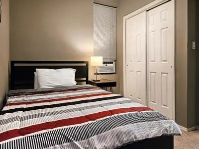 a bedroom with a bed with a white door and a table at Lovely 2BR apartment by Wooster Square- great neighborhood in New Haven