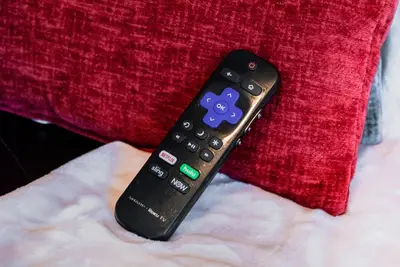 a remote control sitting on top of a red pillow at Lovely 2BR apartment by Wooster Square- great neighborhood in New Haven