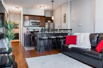 a living room with a couch and a kitchen at Lovely 2BR apartment by Wooster Square- great neighborhood in New Haven