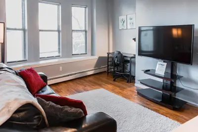 a living room with a couch and a flat screen tv at Lovely 2BR apartment by Wooster Square- great neighborhood in New Haven