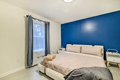 a bedroom with a large bed with a blue wall at 3 Mi to Kalahari Pocono Summit Home with Game Room! in Pocono Summit