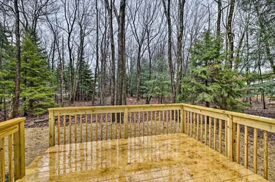 a wooden deck with a view of the woods at 3 Mi to Kalahari Pocono Summit Home with Game Room! in Pocono Summit
