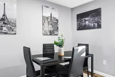 a dining room with a black table and chairs at Lovely 3 Bedroom Colonial home in Middletown