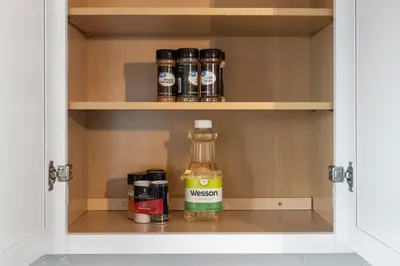 a cabinet with a bottle of alcohol in it at Lovely 3 Bedroom Colonial home in Middletown