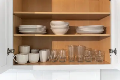 a cabinet filled with glasses and plates and bowls at Lovely 3 Bedroom Colonial home in Middletown