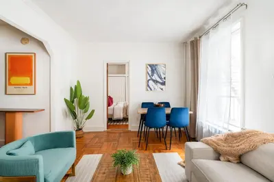 a living room with a couch and blue chairs at 61-2C Prime UES 2BR Newly furnished best value in New York