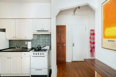 a kitchen with white cabinets and a stove at 61-2C Prime UES 2BR Newly furnished best value in New York