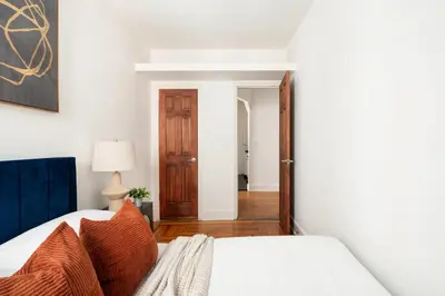 a bedroom with a bed with orange pillows at 61-2C Prime UES 2BR Newly furnished best value in New York