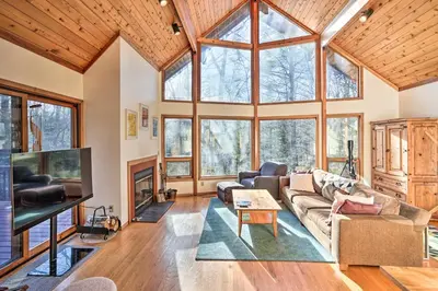 a living room with a couch and a tv at Berkshires Cabin 2 Mi to Appalachian Trail! in Otis