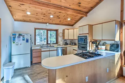 a kitchen with wooden cabinets and a white refrigerator at Berkshires Cabin 2 Mi to Appalachian Trail! in Otis