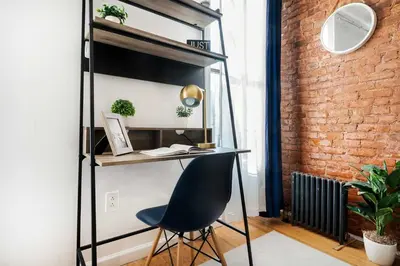 a desk and a chair in a room with a brick wall at 454-4R New 2BR prime midtown Best value Sleeps 5 in New York