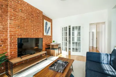 a living room with a brick wall and a flat screen tv at 454-4R New 2BR prime midtown Best value Sleeps 5 in New York
