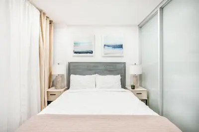 a white bedroom with a bed and two night stands at 75-1A NEW Prime UES W D in unit Elevator in New York
