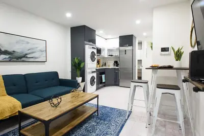 a living room with a blue couch and a table at 75-1B NEW Prime Upper East W D Elevator in New York
