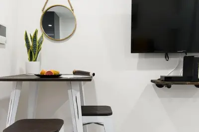 a mirror on a wall next to a table with stools at 75-1B NEW Prime Upper East W D Elevator in New York